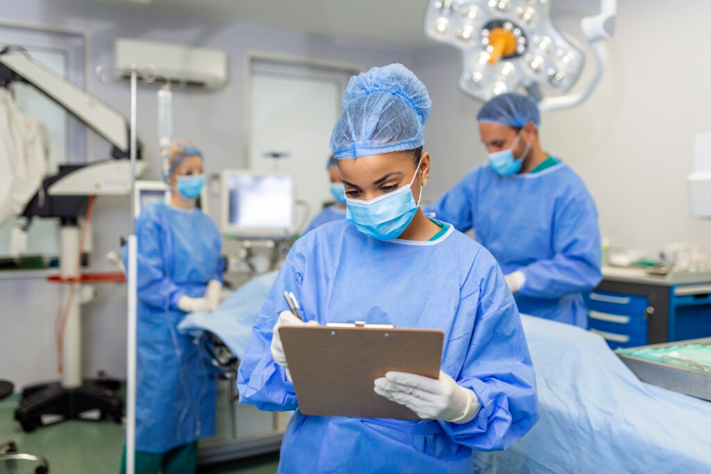 surgeon writing on clipboard in operation room, anaesthesiologist writing the updates